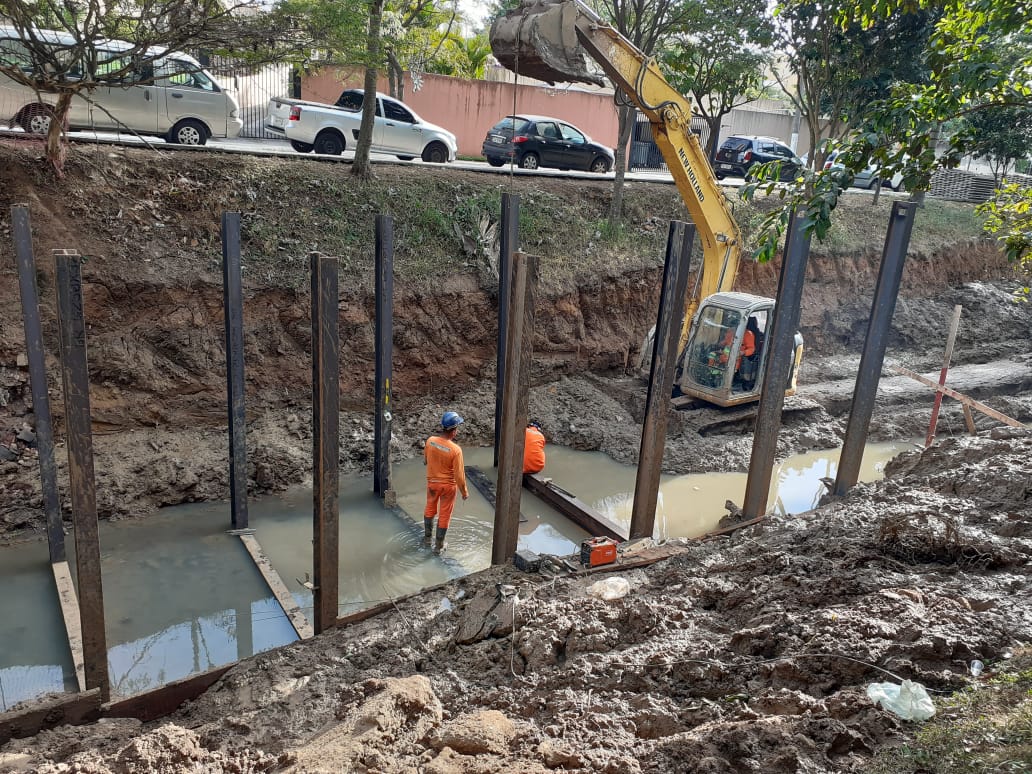 pessoas trabalhando na contenção de margens de corrego